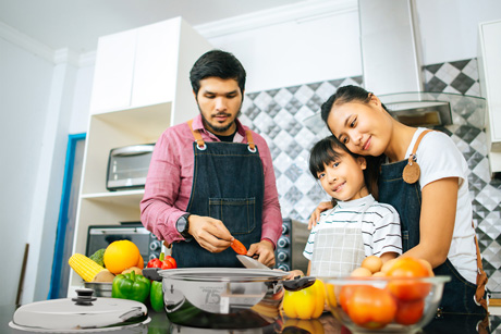 Family cooking with fresh vegetables and Saladmaster cookware during a healthy cooking class at the Cook School in Penrith.