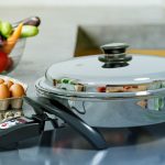 Saladmaster Electric Oil Core Skillet with fresh eggs and vegetables on a blue benchtop