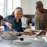 Elderly women serving healthy Saladmaster meals to a young girl using waterless cooking and non-toxic cookware techniques.